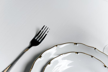 Top view fork and plate on a light surface