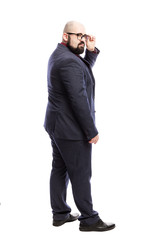 Fat bald man with a beard in glasses in a strict suit. Full height. Back view. Isolated over white background. Vertical.