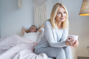 Relaxed woman enjoying tea in bedroom stock photo