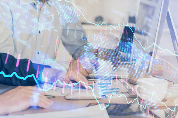 Multi exposure of chart with man typing on computer in office on background. Concept of hard work.