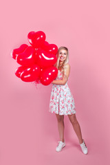 Valentine girl with red air balloons on pink background.