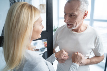 Fototapeta premium Couple standing hand in hand and smiling stock photo