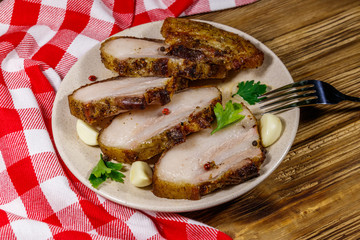 Baked pork belly in a plate on wooden table