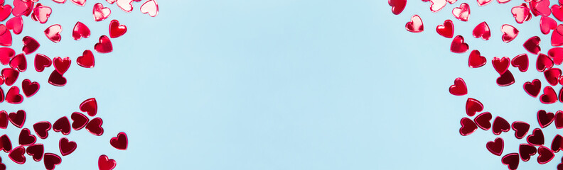 Red heart shaped confetti on blue background,