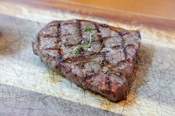 Medium rare meat on wooden plate