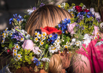 Naklejka premium summer solstice wreath on head, handmade, individual parts in focus, summer day