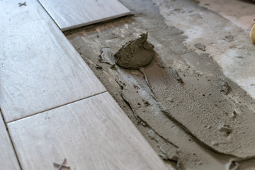 Close up shot of unfinished floor tiles installation in kitchen