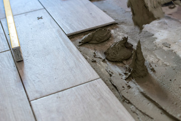 Close up shot of unfinished floor tiles installation in kitchen