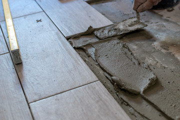 Close up shot of unfinished floor tiles installation in kitchen