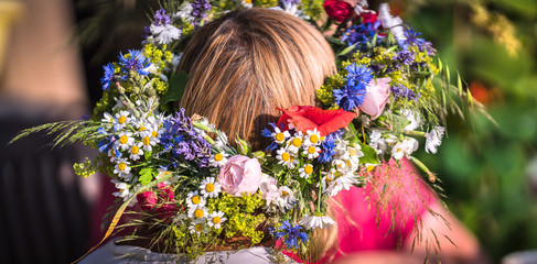 Naklejka premium summer solstice wreath on head, handmade, individual parts in focus, summer day