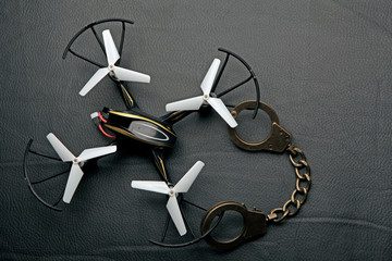 quadcopter handcuffs dark leather background