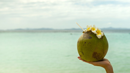 Travel concept. Coconut with flowers on sand beach, Banul beach, Coron, Palawan, Philippines