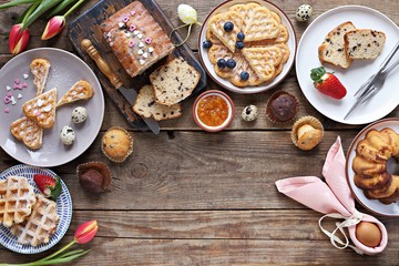 Easter festive dessert table with various of cakes, waffles, sweets and strawberry. Overhead view