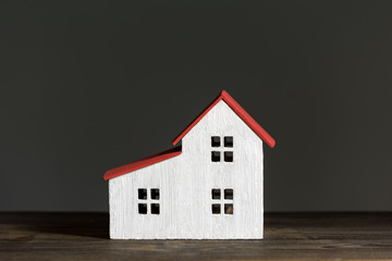 Miniature house on black background. Home construction concept. Front view.