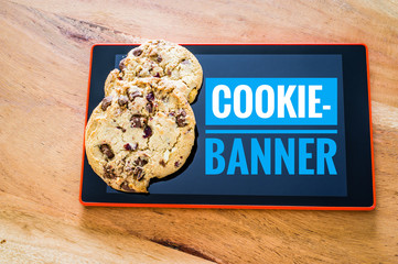 Cookies mit einem Tablet zur Verdeutlichung von Cookie Bannern für Websites mit Cookie-Banner