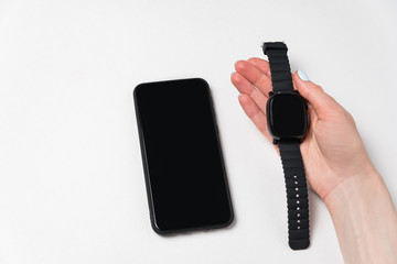 Phone and smart watch in hand. White background. App template. Copy space