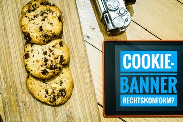 Cookies mit einem Tablet zur Verdeutlichung von Cookie Bannern für Websites mit auf deutsch...
