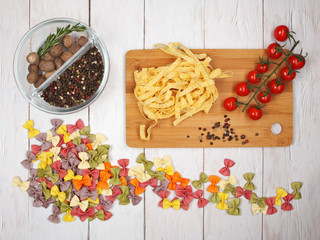 Dry Italian pasta fettuccini and farfalle with tomatoes, rosemary, mixture of peppers and whole...