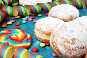 Carnival powdered sugar raised donuts with paper streamers. German berliner or krapfen for carnival