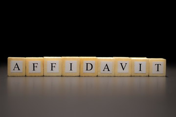The word AFFIDAVIT written on wooden cubes isolated on a black background...