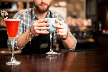 Bartender holding a beautiful glass with a cocktail