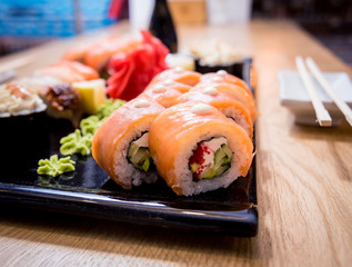 Sushi set. Rolls with salmon, eel and red caviar on a wooden plate. Restaurant.