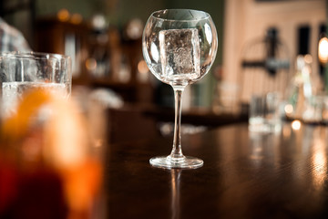 Empty clean glasses with ice at the bar counter