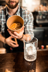 Smiling bartender holding a box with orange slices