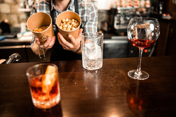 Young bartender is holding ingredients for cocktails