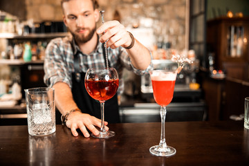 Cropped photo of bartender is stirring a cocktail