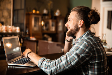 Smiling bartender making an order on smartphone