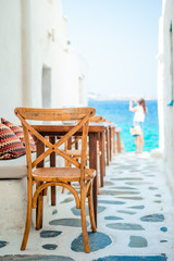 Benches with pillows in a typical greek outdoor cafe in Mykonos with amazing sea view on Cyclades islands