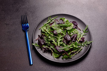 Healthy food, salad mix with arugula, spinach, bulls blood, beet leafs and micro greens