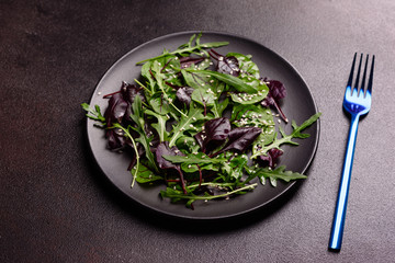 Healthy food, salad mix with arugula, spinach, bulls blood, beet leafs and micro greens