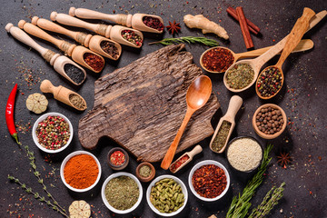 Spices and herbs over black stone background. Top view with free space for menu or recipes