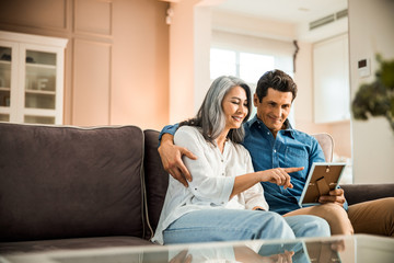 Happy adult couple in love looking at photo frame in room