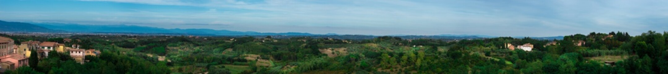 Wide panorama shot of a beautiful Italian landscape with mountains and cities
