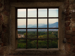 A view through barred window to the beautiful panorama of a mountain city