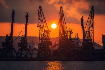 Obraz premium Sunset over sea port and industrial cranes, Varna