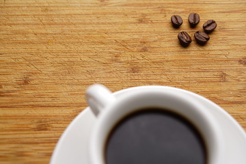 Coffee and beans with white cup and wood