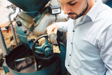 Barista roasting coffee with a machine