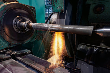 Grinding and high-precision shaft processing on a circular grinding machine with sparks and cooling.