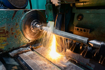 Grinding and high-precision shaft processing on a circular grinding machine with sparks and cooling.