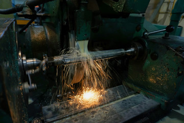 Grinding and high-precision shaft processing on a circular grinding machine with sparks and cooling.