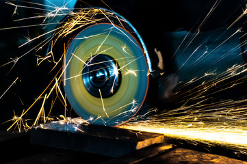 Cutting abrasive wheel on a grinder in work, closeup.