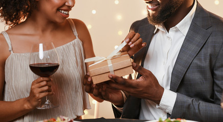 Charming afro man giving present to his woman