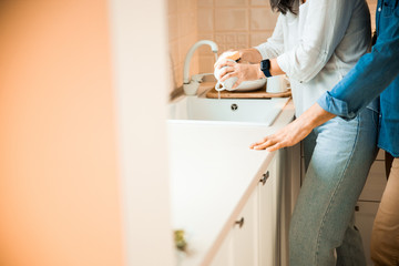 Woman is washing a cup in the kitchen