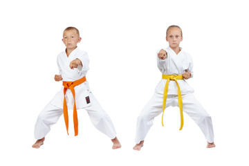 Two children in karategi beat kick gyaku-tsuki