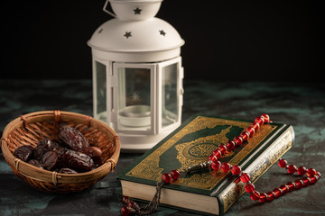 Islamic concept: The holy Quran and Tasbih (rosary beads) on dark background