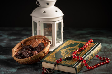 Islamic concept: The holy Quran and Tasbih (rosary beads) on dark background
